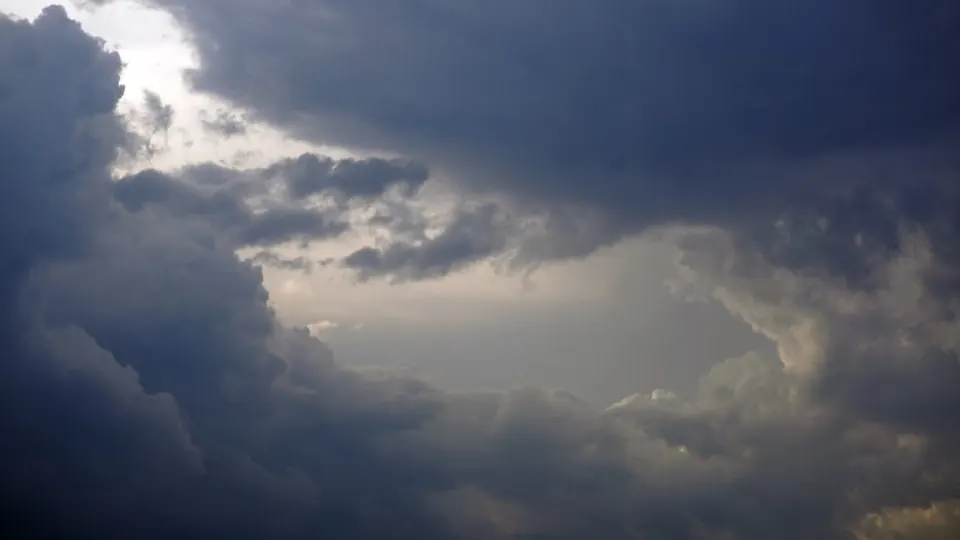 A tall thunderstorm cloud building over open country